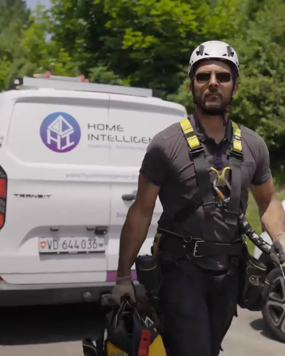Technicien Home Intelligence debout devant un véhicule d'intervention, prêt pour un chantier solaire en Suisse romande