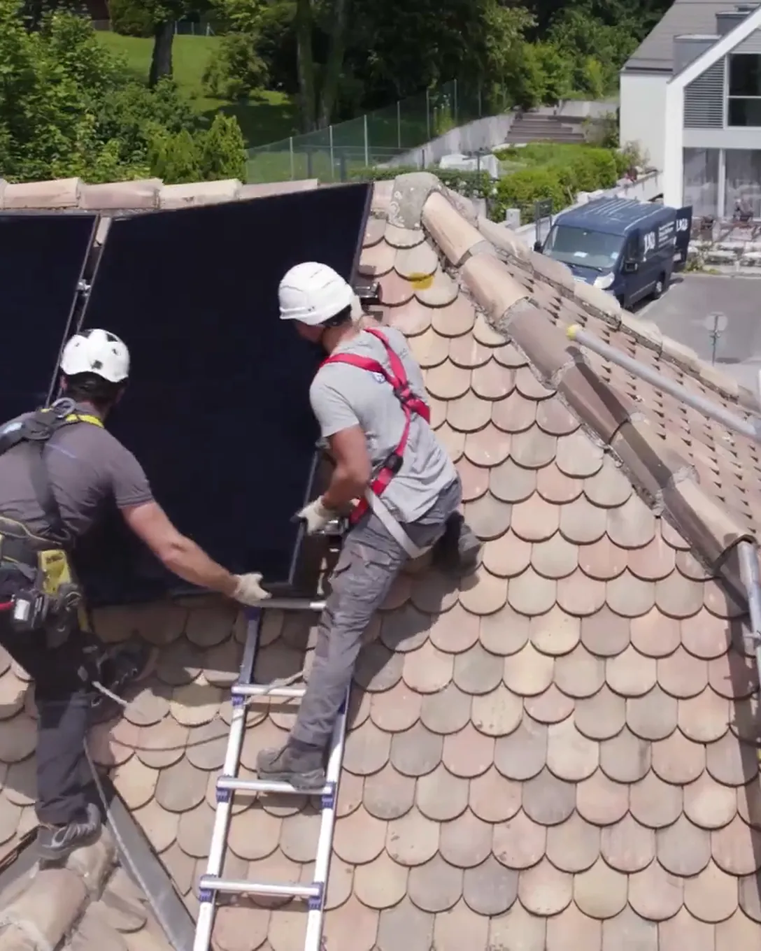 Techniciens Home Intelligence posant des panneaux solaires sur un toit en Suisse romande